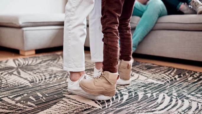 脚，跳舞和乐趣在地板上，连接和游戏或信任，帮助和支持在家里的客厅。鞋子，家庭乐趣和学习或照顾，运动和