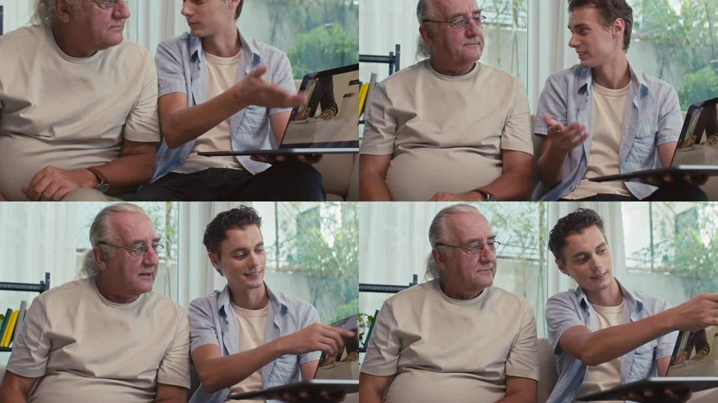 一个男人拿着无线电脑和他成熟的父亲说话
