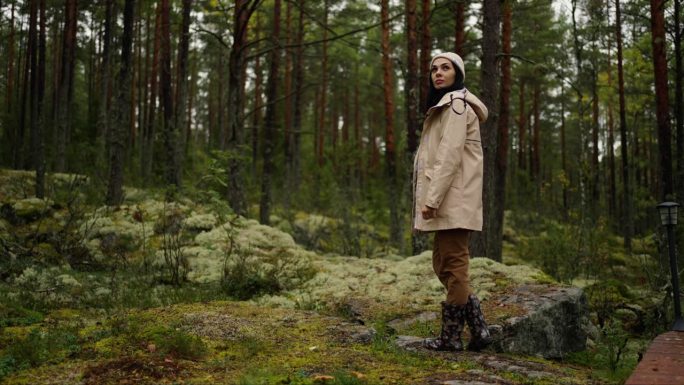 年轻女子独自走在挪威或加拿大的森林里，穿着运动服的女士肖像