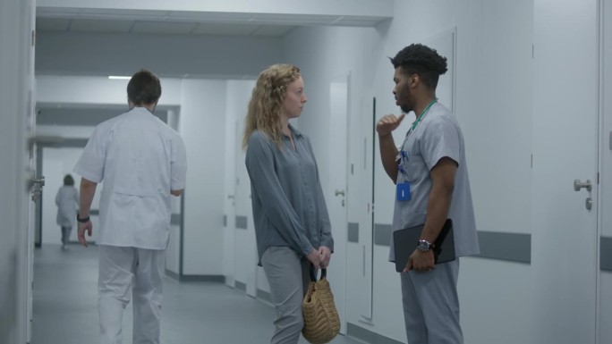 非裔美国医生和一名妇女站在医院走廊上