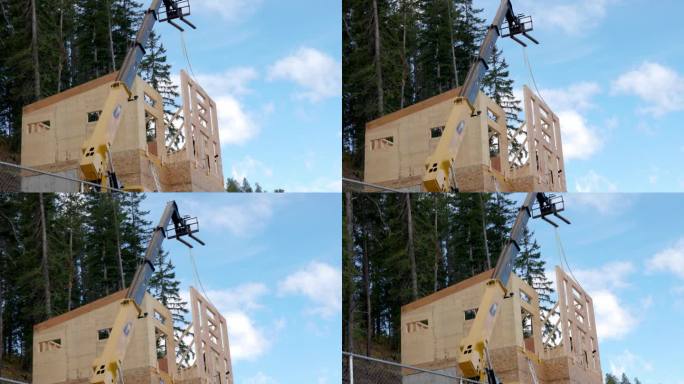 吊车帮助竖立房屋前墙的景象