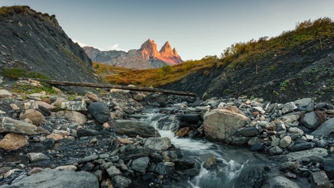 在法国萨瓦的秋天，法国阿尔卑斯山脉的Aiguilles d Arves山谷中标志性的三峰山和瀑布的景