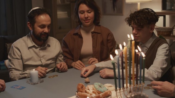 犹太男孩与家人玩纸牌游戏并获胜