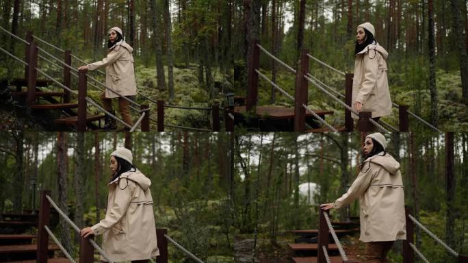 女游客在森林里参观国家保护区公园，在木楼梯上移动