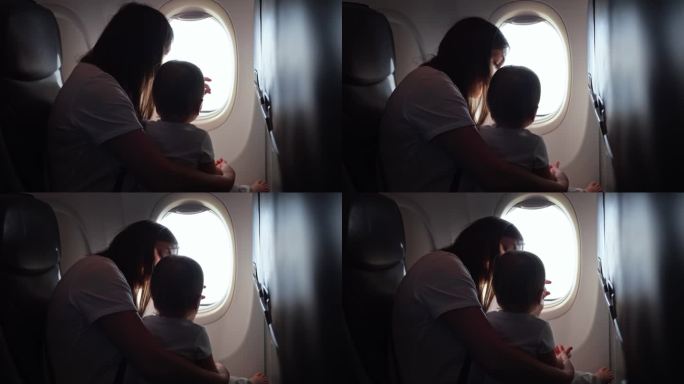 妈妈和孩子坐飞机，妈妈从窗户看风景