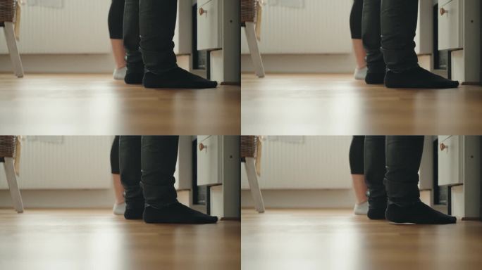 两个人站在厨房里，他们的脚的特写