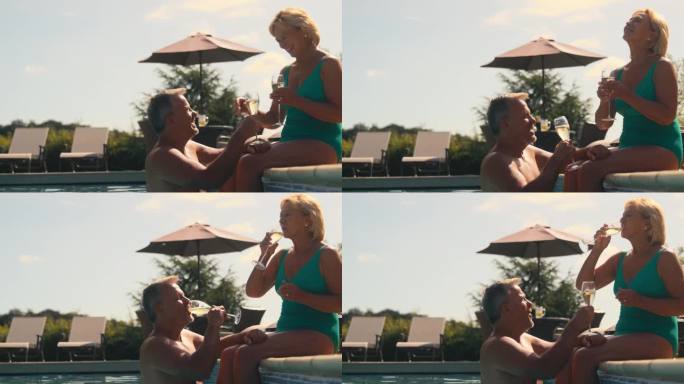度假的老夫妇穿着泳装，在酒店游泳池旁喝香槟庆祝