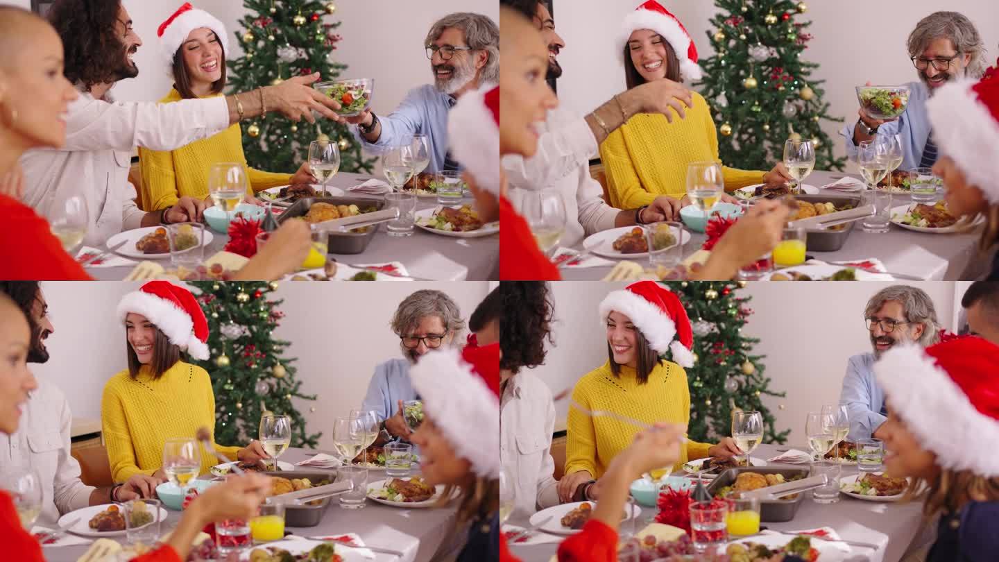 圣诞午餐时，一家人欢声笑语地围坐在餐桌旁。家庭生活的人。