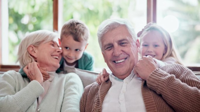微笑，爱和孩子拥抱祖父母在客厅的沙发在现代家庭。家庭，纽带或肖像的孩子拥抱老人和退休妇女与照顾在休息