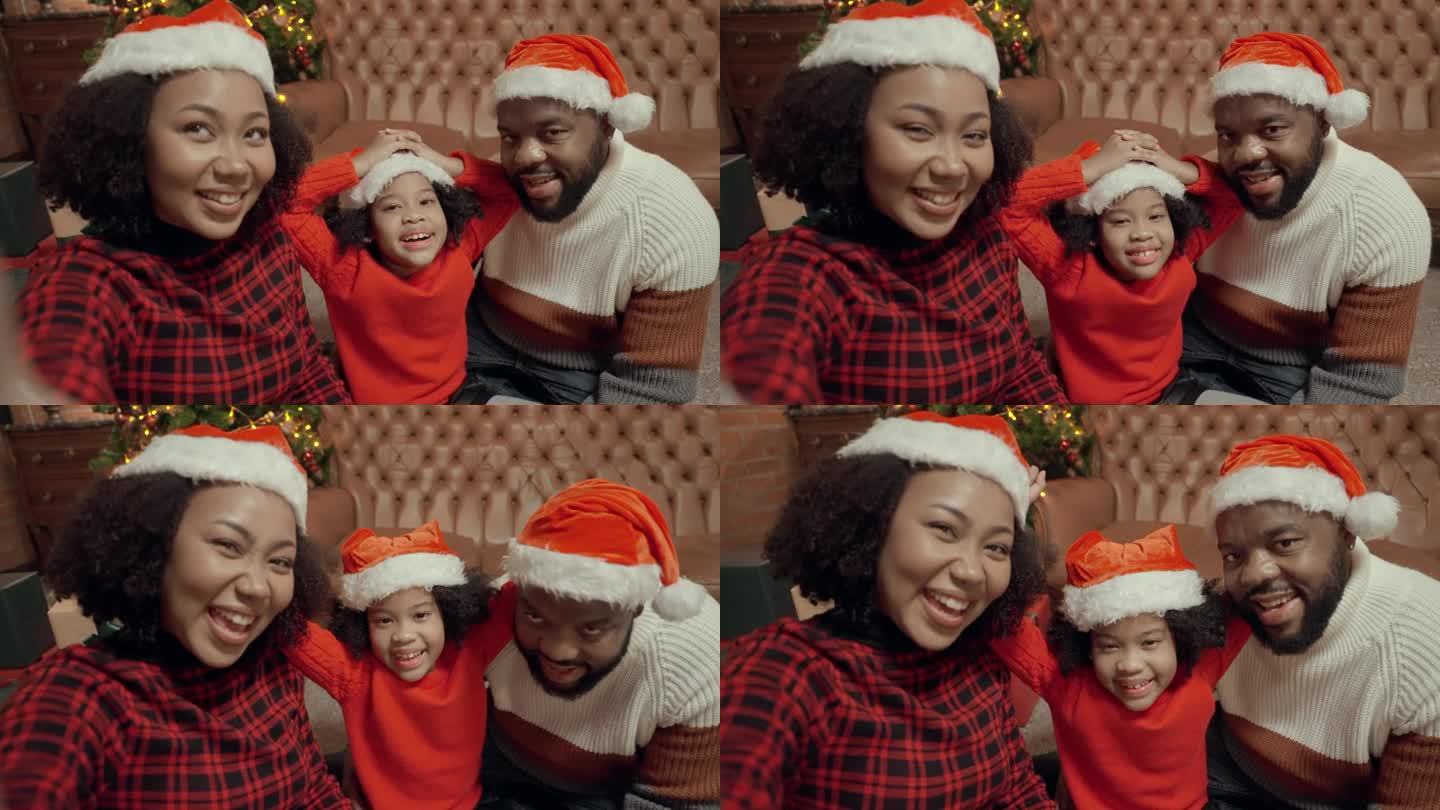 一个微笑的非洲家庭，黑人父亲和母亲在家里拥抱着他们快乐的小女儿庆祝圣诞节。他们满怀爱意地对着对方微笑