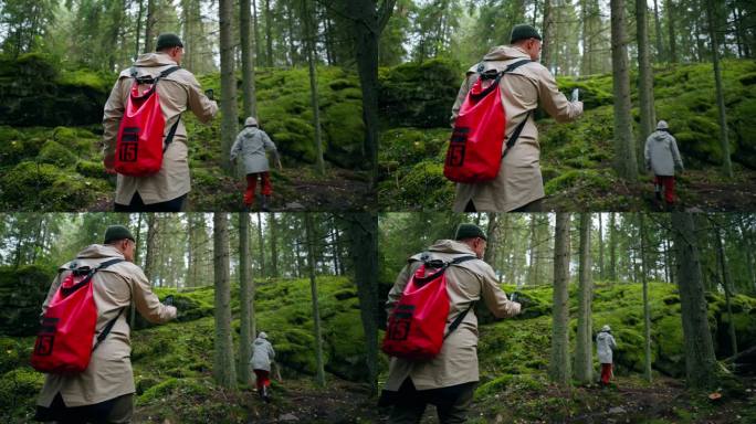 旅行博主在神奇的森林里散步，男人在林地里拍摄手机照片或视频