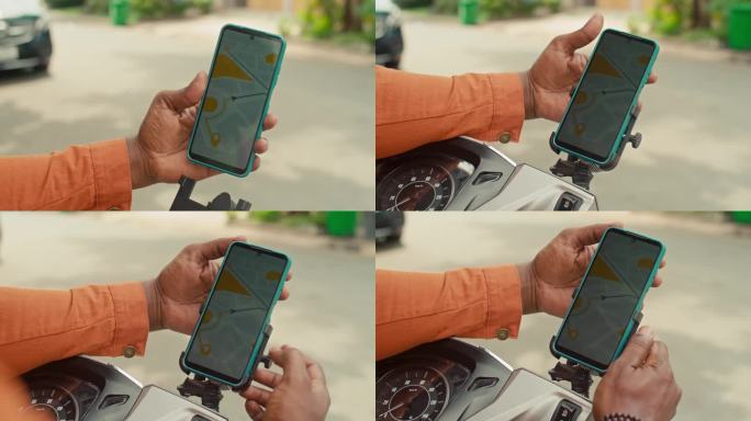 一位匿名男子在骑摩托车前用智能手机看电子地图