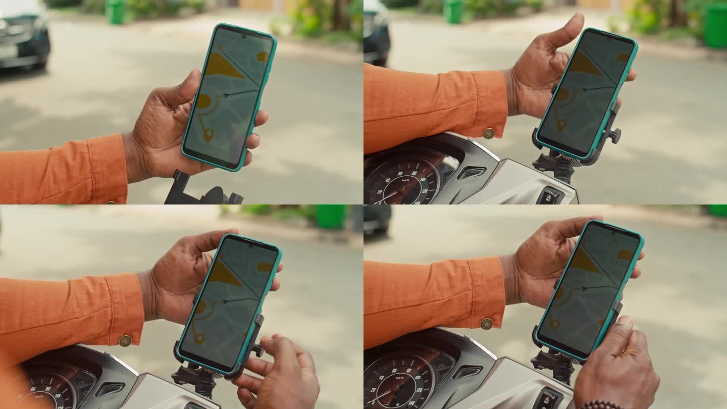 一位匿名男子在骑摩托车前用智能手机看电子地图