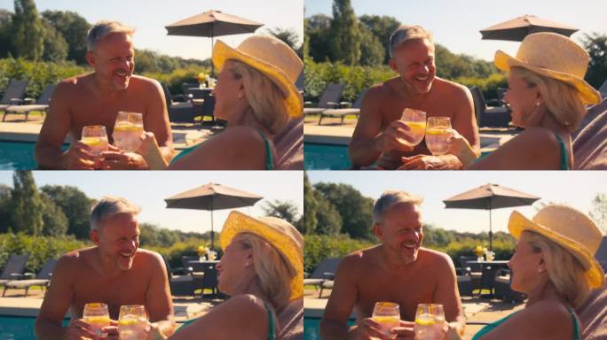 度假的老夫妇穿着泳衣在酒店游泳池边喝饮料欢呼