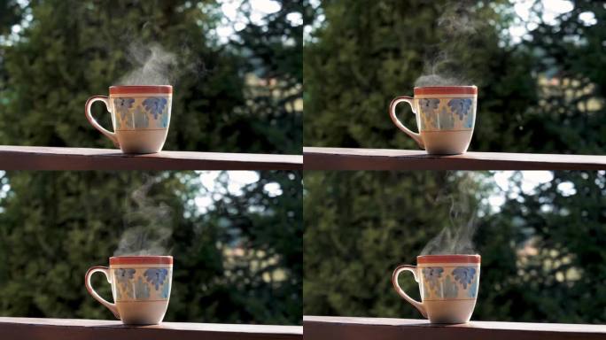 一杯热茶咖啡放在乡村别墅阳台的木扶手上