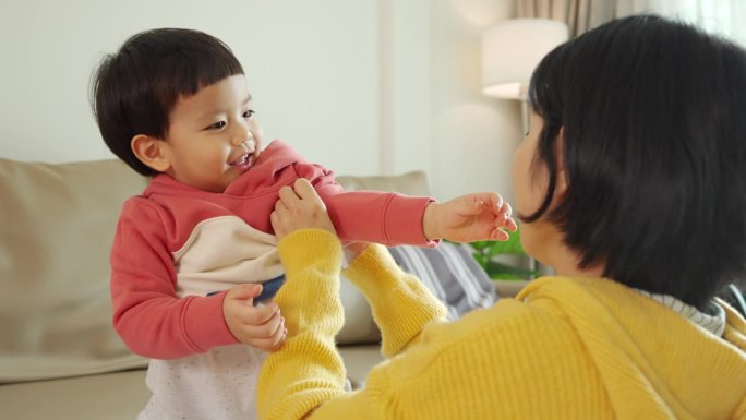 亚洲华人母亲给儿子穿衣服