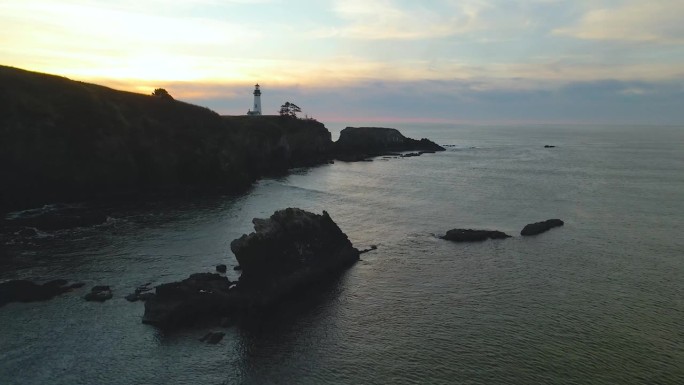 航拍照片，在俄勒冈州纽波特向一座灯塔推进，眺望夕阳。