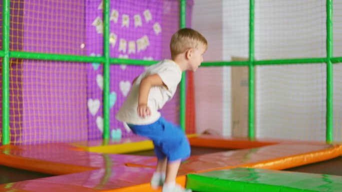 一个孩子在游乐场的蹦床上蹦蹦跳跳。操场上活跃的儿童游戏