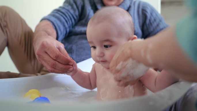 洗澡，洗澡和家长用肥皂为宝宝清洁，卫生和健康在浴缸在家里。家庭，儿童保育，爸爸妈妈带着新生儿，孩子和