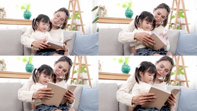 亚洲漂亮的孕妇妈妈在闲暇时间和大女儿一起在客厅看书，妈妈教宝宝读书，给小孩子讲故事。家庭幸福观
