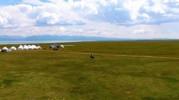 骑马的人和游牧的蒙古包在草地上扎营