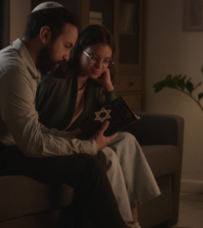 犹太男子在基帕与女儿在光明节学习托拉