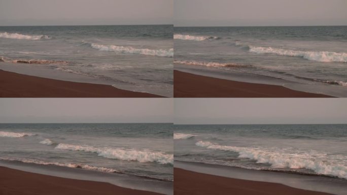 日落时海浪冲击海滩的慢动作视频