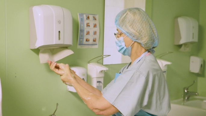 手术前，一位资深女外科医生按照绝育规则洗手。医生在进入手术室前先消毒并洗手干。手消毒。