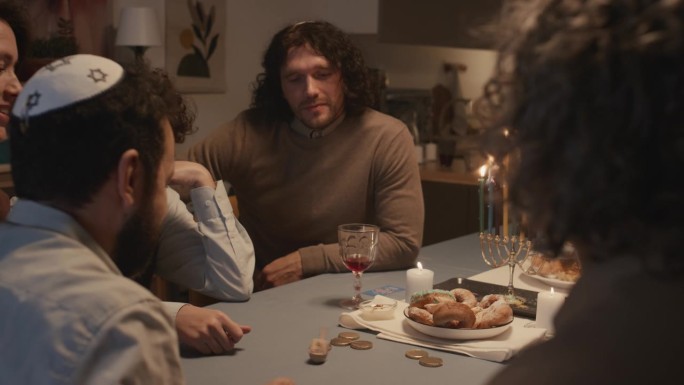 犹太家庭在光明节晚餐上玩纸牌游戏