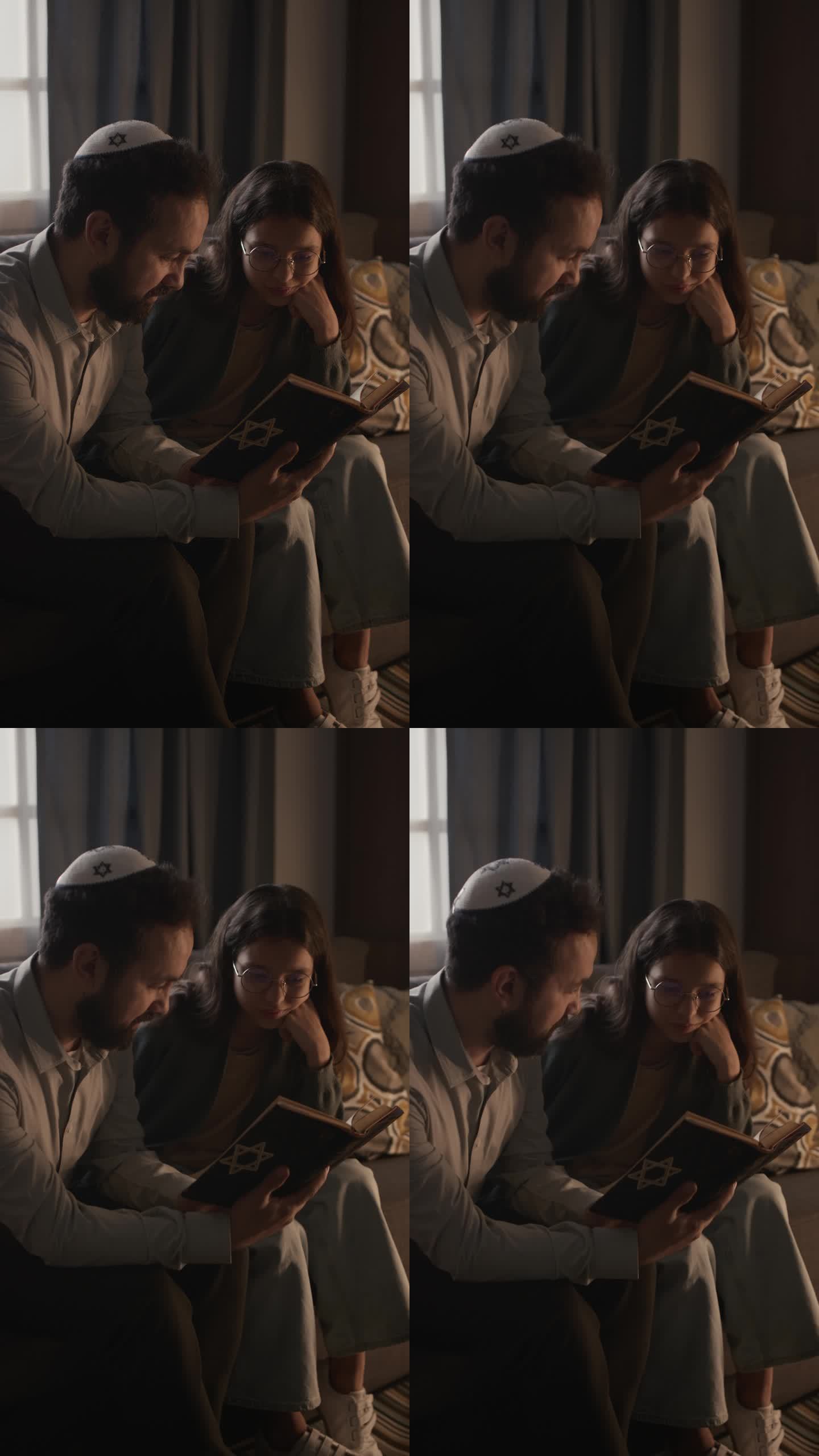戴着圆顶便帽的中年犹太男子和女儿一起读摩西五经