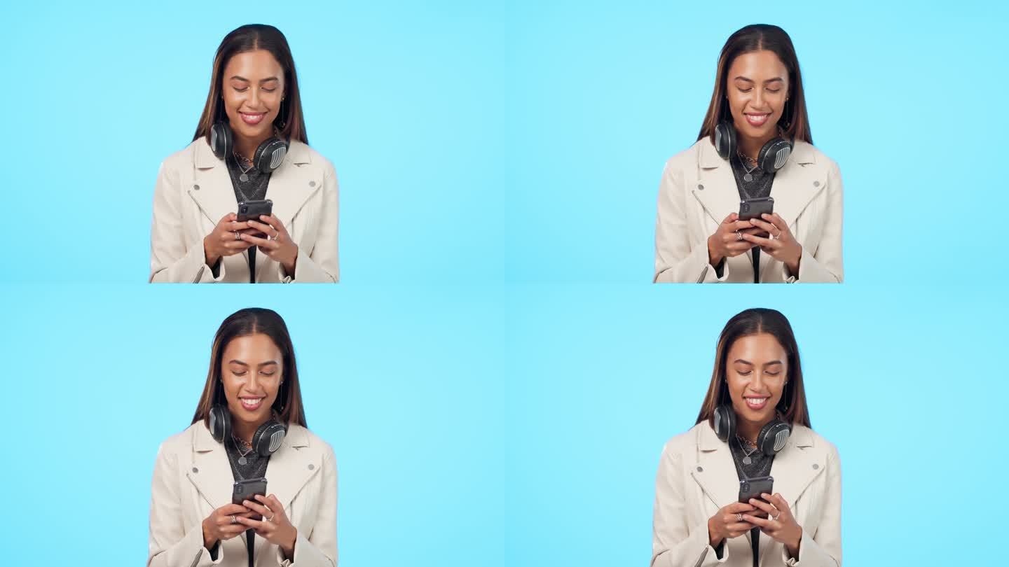 女人，在智能手机上打字，在社交媒体上交流，在蓝色背景的表情包上微笑。耳机，短信和年轻女性聊天，互联网