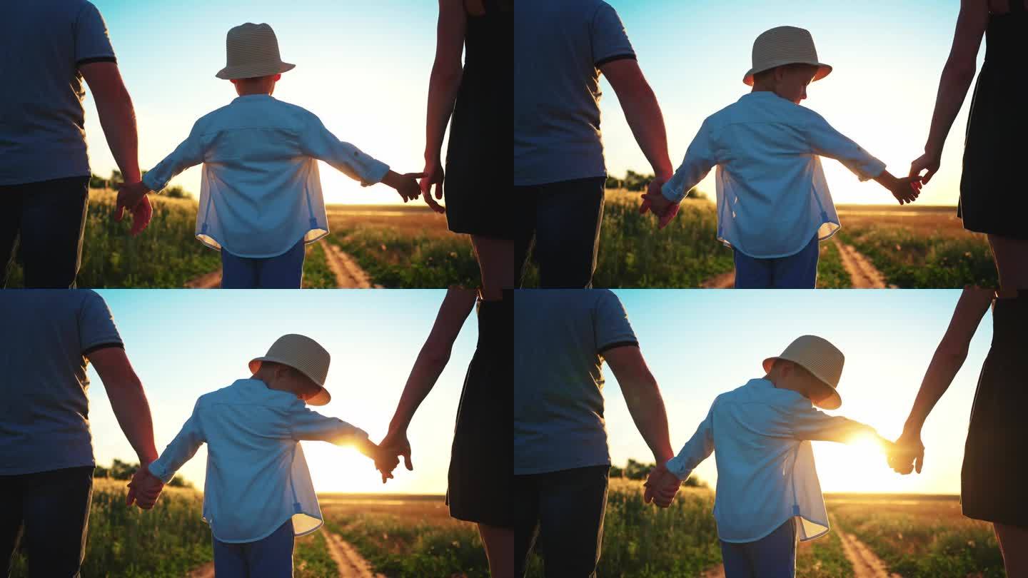 夏天的田野里，孩子站在父母中间，互相伸出手，一家人牵着手。争吵后的团队精神和关系中的和解。心理学手势