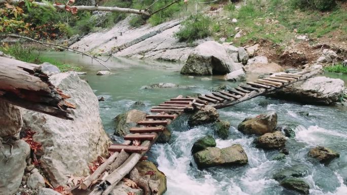 木桥横跨清净的山河，彰显生态。木桥下河水清流，生态保存。木桥下干净水域生态明显