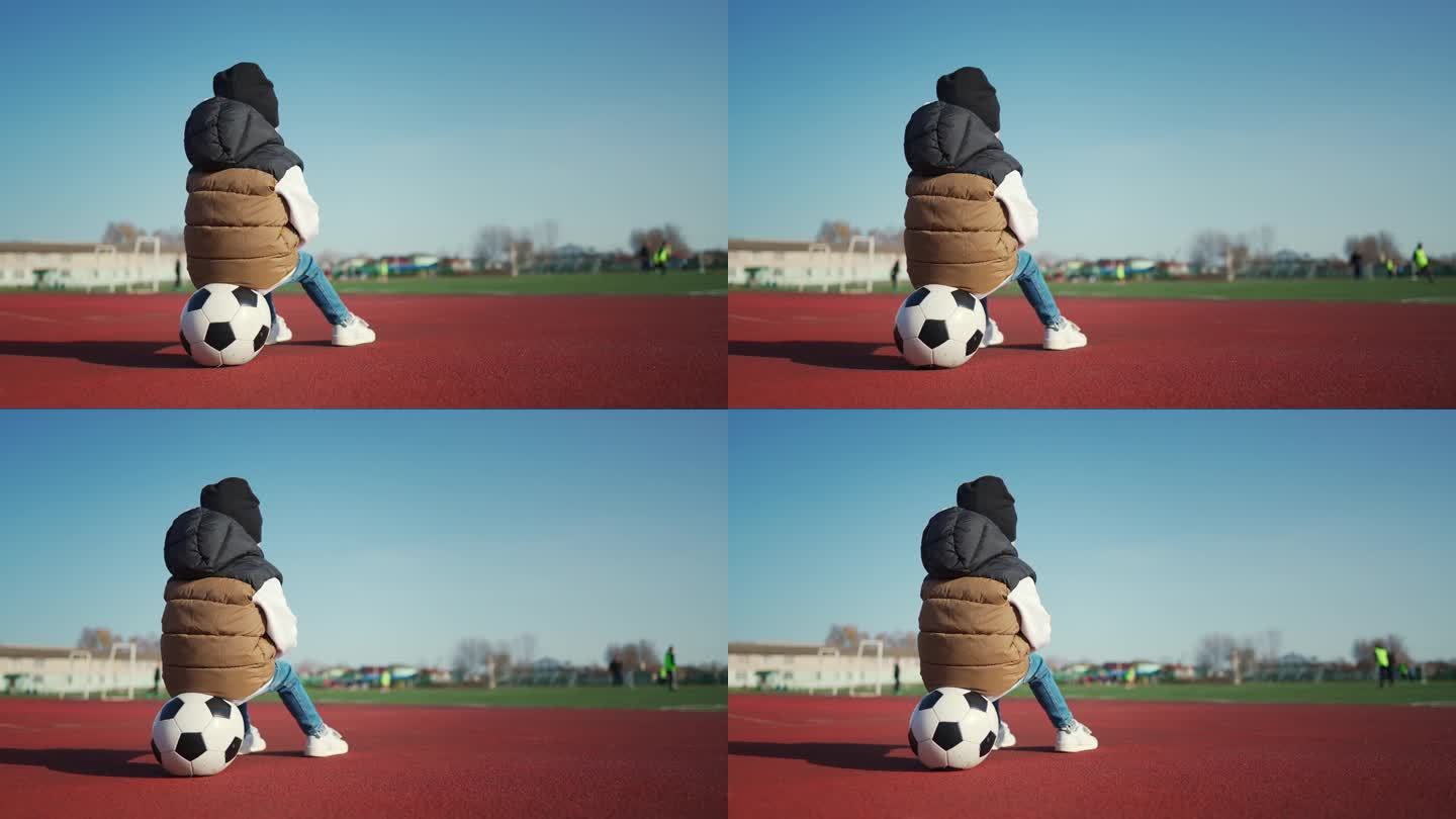 小男孩在足球场拿着足球。未来的足球明星。足球训练理念。