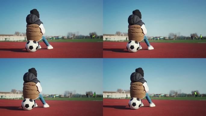 小男孩在足球场拿着足球。未来的足球明星。足球训练理念。