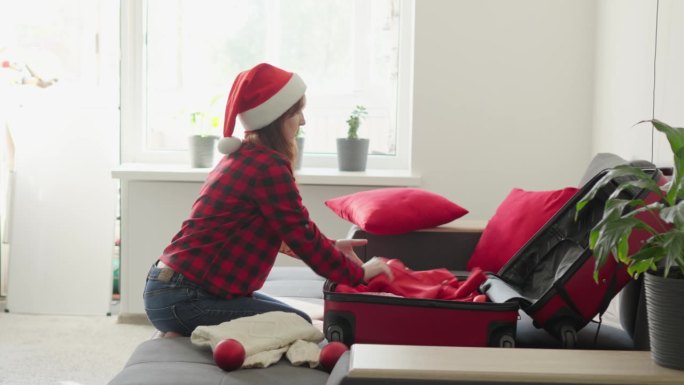 一名妇女为新年假期准备咒语。冬季旅游和假期。在平安夜叠箱子戴圣诞帽的女孩