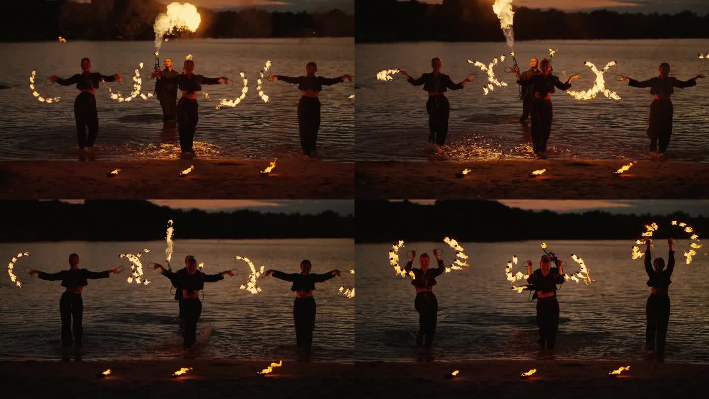 湖岸江畔艺术表演中的火与水，年轻苗条的女子在表演