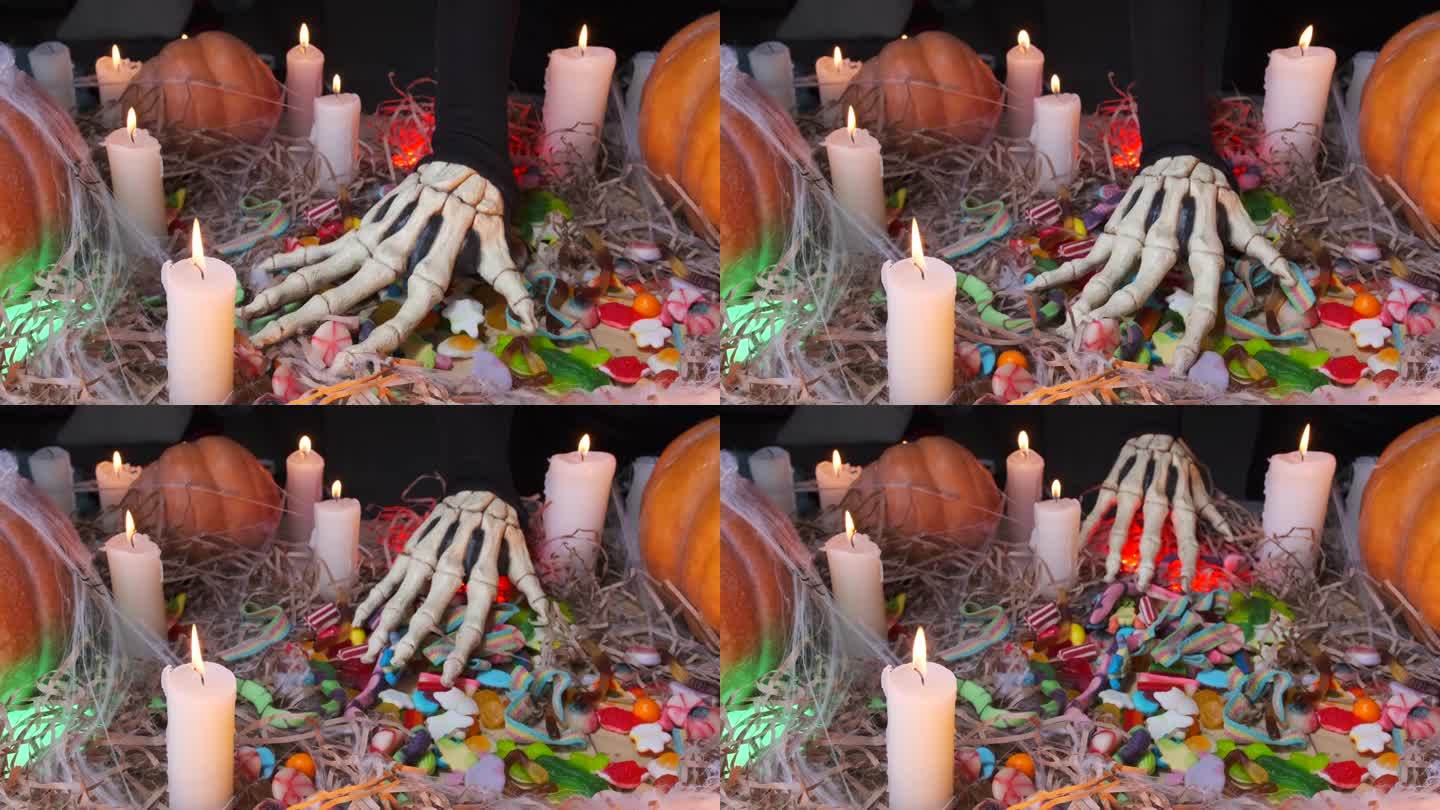 贪婪的怪物伸出他瘦骨嶙峋的手，抚摸着在晚会上收集的糖果。万圣节快乐。