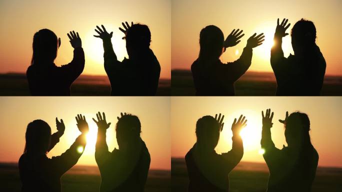 伸出援手的剪影，希望和支持在夕阳下的彼此。人们的手伸向天空，遮住太阳，太阳的光线穿过手。宗教概念镜头
