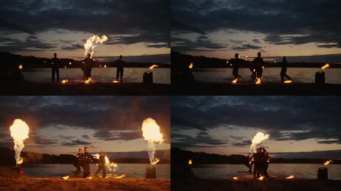 夏夜河岸壮观的火秀，火焰向上移动，人们的剪影