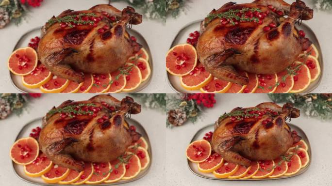 整只烤鸡配石榴和红橙，脆脆可口。传统的新年和圣诞节菜肴。背景是圣诞装饰。特写，选择性对焦，变焦