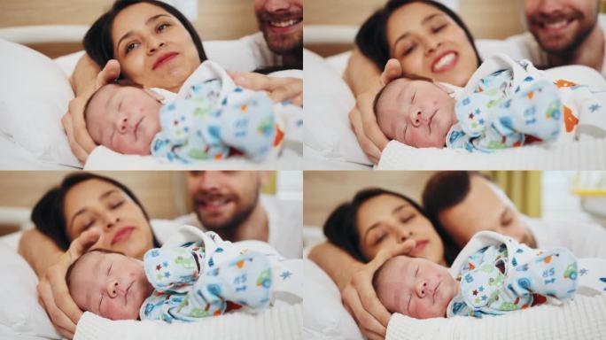 在分娩中心，刚出生的男婴被新妈妈和新爸爸抱着。初为父母的脸上洋溢着喜悦和幸福的情绪。快乐的多民族家庭