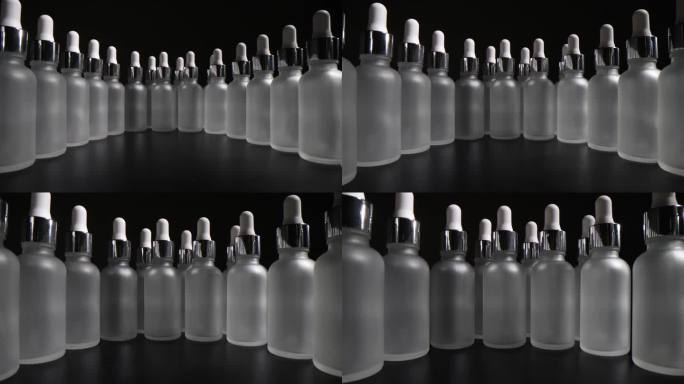 灰色背景上的一排化妆品空玻璃瓶