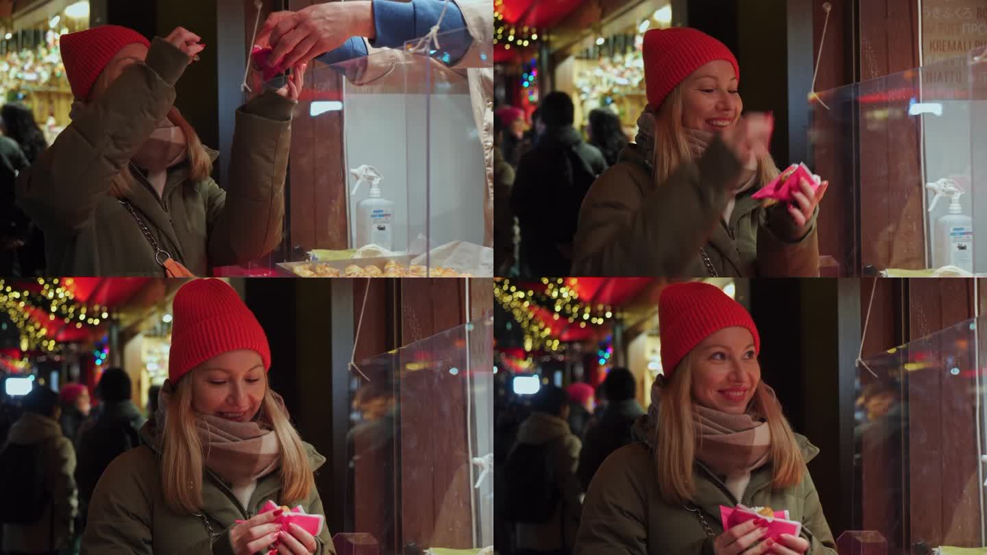 一个女孩在科隆市中心的圣诞集市上买糖果