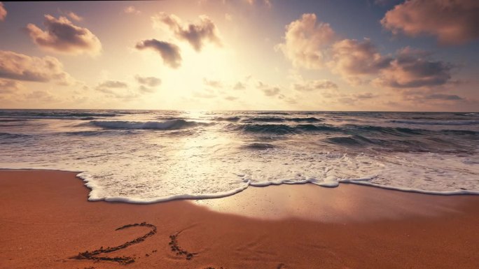 2024年新年的文字写在沙滩上的热带海滩，在美丽的日出，云在海浪和异国情调的岛屿