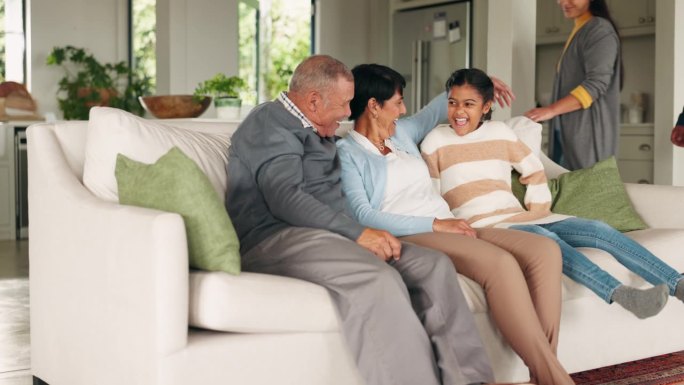 祖父母、父母或孩子在家里的客厅里看电视，在假期里拉近彼此的距离。快乐的家庭，奶奶或爸爸微笑着与妈妈、