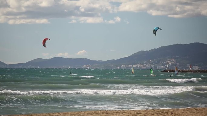 极限水上运动，人们正在西班牙海滩附近的海洋里玩风筝冲浪