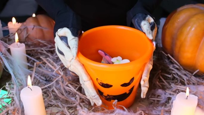 在Сlose-up上，贪得无厌的孩子们穿着骷髅服装要求糖果，并展示了装满糖果的桶。