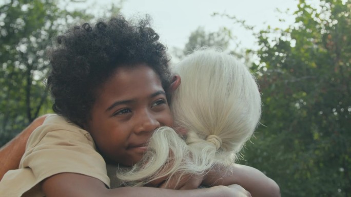 快乐的非裔美国男孩拥抱他的爷爷