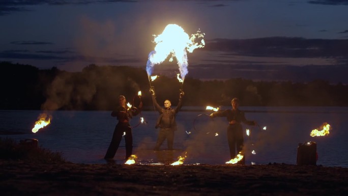 夜江岸边迷人的火焰表演，特技人员玩火